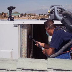 HVAC Tech Performing Cleaning on Commercial HVAC System